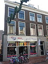 Pand met bakstenen gevel met rechte kroonlijst, bovenverdieping met pilasters, onderpui verbouwd