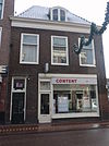 Pand met gevel met rechte kroonlijst en Louis XIV dakvenster, onderpui verbouwd.