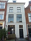 Pand met gepleisterde lijstgevel. Stoep met stoeppalen