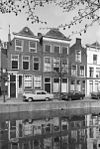 Pand met gedrukte tuitgevel, afgedekt met kroonlijst en zijgevel op hoek. Goede onderpui