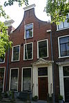 Pand met tuitgevel, Lod. XV deuromlijsting en gesneden Lod. XVI deur. Empire hardstenen stoep met palen en kettingen