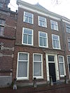 Pand met lijstgevel, houten deuromlijsting. Hardstenen stoep met palen
