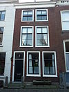Pand met gevel met rechte kroonlijst. Stoeppalen