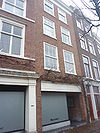 Pand met gepleisterde gevel met rechte kroonlijst. Nieuwe onderpui