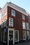 Hoekhuis Lange Pieterskerkkoorsteeg. Twee gevelstenen met leeuwenmaskers en opschriften 