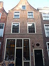 Pand met tuitgevel. Tudorbogen boven vensters op tweede verdieping
