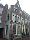 Pand met tuitgevel, deuromlijsting, hardstenen stoep en palen, afgedekt segmentvormig fronton