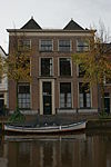 Pand met gevel met rechte kroonlijst. Deuromlijsting Lod. XVI. Hardstenen stoep met palen, oorspronkelijk twee huizen
