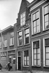 Pand met topgevel met rudimenten van trappen, korfbogen boven vensters