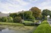 Overzicht boerderij in straatbeeld met sloten rond erf