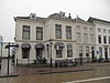 L-vormig hoekpand met gepleisterde lijstgevel, verdieping en schilddak