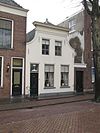 Pandje met ingezwenkte en gepleisterde gevel, afgedekt door een houten kroonlijst