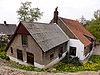 Boerderij, met woonhuis, dat in de voorgevel vensters met roedenverdeling uit de bouwtijd heeft. Hogere stal onder zadeldak tussen puntgevels met vlechtingen