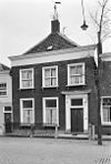 Pand met verdieping en schilddak, waarop schoorsteen met smeedijzeren sierbekroning