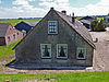 Boerderij. Kattendijk 183 -  Boerderij in Gouderak onder rieten zadeldak met puntgevel. In de gevel zijn vlechtingen, sieranker en gekoppelde ontlastingsbogen boven de ramen.  Farm in Gouderak with a thatched roof 