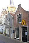 Dorpsstraat19 Ouderkerk aan den IJssel -  Dubbelpand Dorpsstraat 19 in Ouderkerk aan den IJssel, zowel het rechterpand met het uithangbord als het linkerpand met de gepleisterde gevel vormen tesamen Dorpsstraat 19, ook zichtbaar het hoekpand 