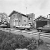 Gepleisterd huis, met gevels waarin gekoppelde rondboogvensters in geprofileerde, houten omlijstingen