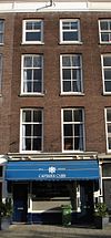 Pand met drie verdiepingen. Rijk geprofileerde houten kroonlijst waaronder fries met panelen. Winkelpui uit de bouwtijd