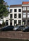 Pand met gepleisterde lijstgevel. Oudere deur in Lod. XVI vormen met eenvoudig bovenlicht en hoofdgestel
