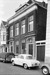 Herenhuis met lijstgevel, bestaande uit een terugliggend gedeelte en twee hoekrisalieten, waarin natuurstenen deuromlijstingen