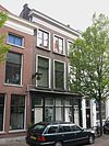 Pand van parterre en twee verdiepingen, ter breedte van drie vensterassen. Zadeldakje. Lijstgevel van karakter derde kwart 19e eeuw
