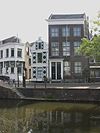 Gerend pand met lijstgevel. Hardstenen plint en vensterdorpels, dubbele deur in omlijsting van pilasters met Korinthische kapitelen. In de vensters schuiframen uit de bouwtijd. Stoep met palen en hekken