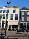 Pand met gepleisterde gevel waarvan de kroonlijst tandingen bezit. Schilddak