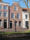Pand met op eigen gelegenheid herstelde gevel met ingezwenkte zijkanten