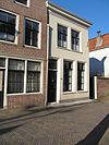 Pand, met aan de achterzijde een puntgevel en in de voorgevel, schuiframen met gegroefde middenstijlen