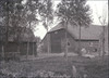 Overzicht van de achterzijde van de boerderij, de zogenaamde waterstal, met een dubbel openslaande deur, geheel links een gedeelte van een losstaande schuur